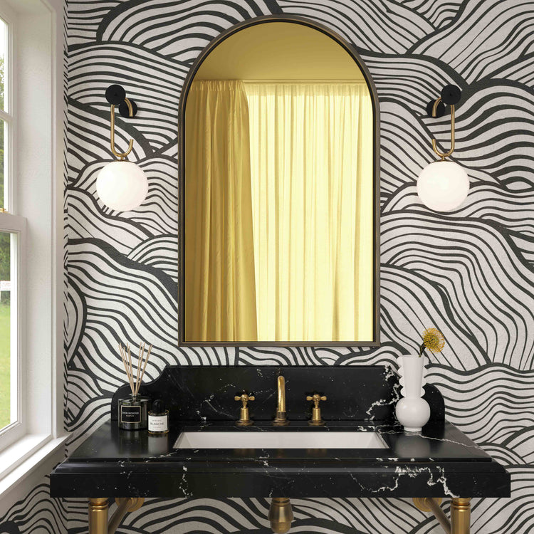 Espejo de pared entintado dorado Harvey arriba de un lavabo.