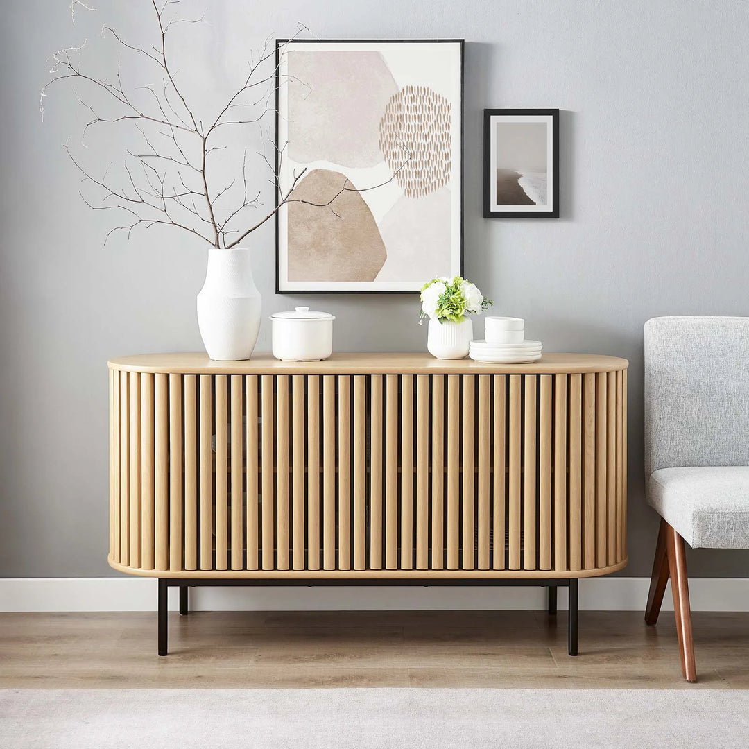 Credenza ovalada con madera estriada color roble Veron en una sala de frente.