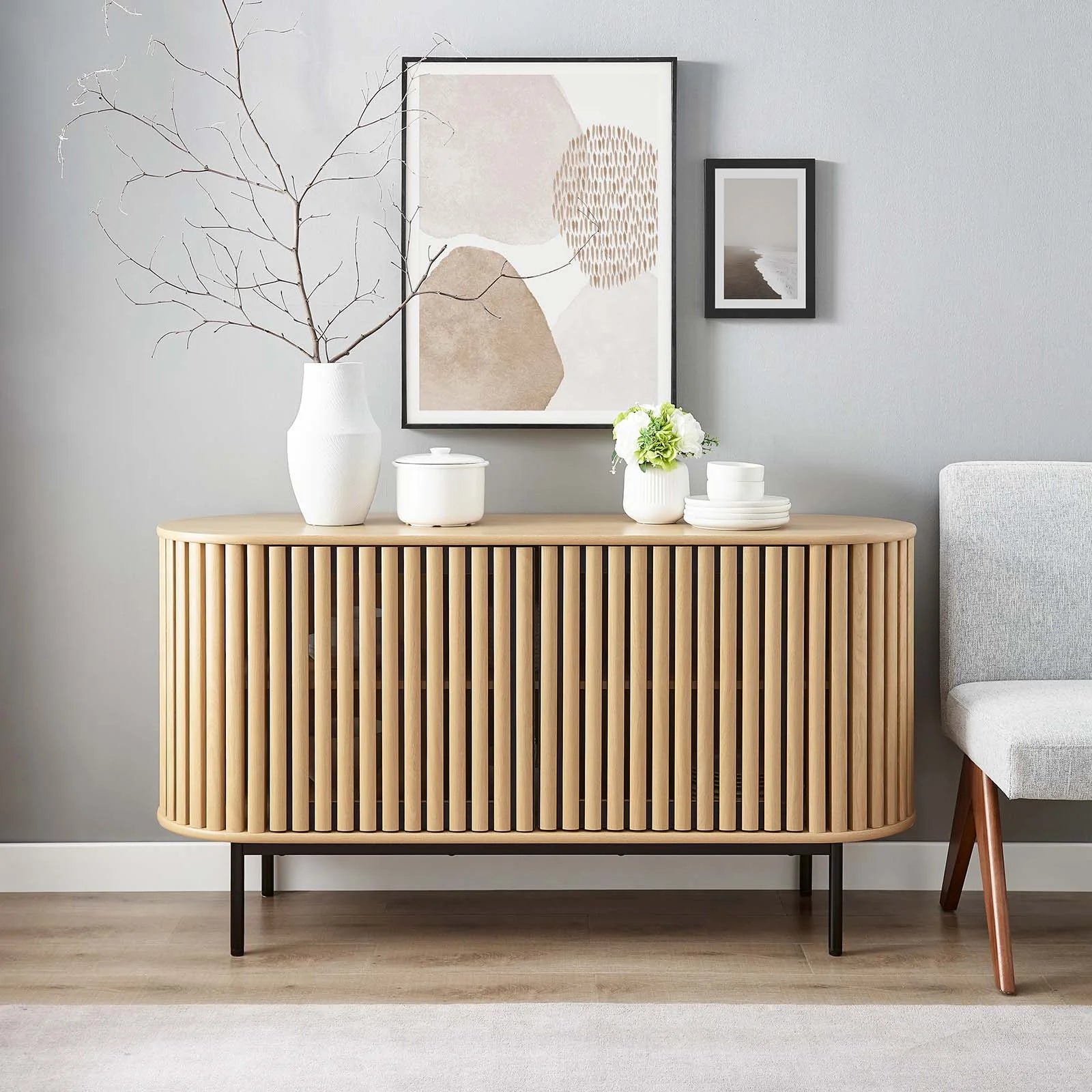 Credenza ovalada con madera estriada color roble Veron en una sala de frente.