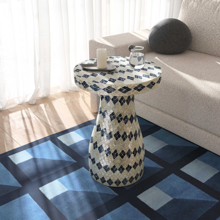 Mesa lateral Astrid crema azul en una sala.