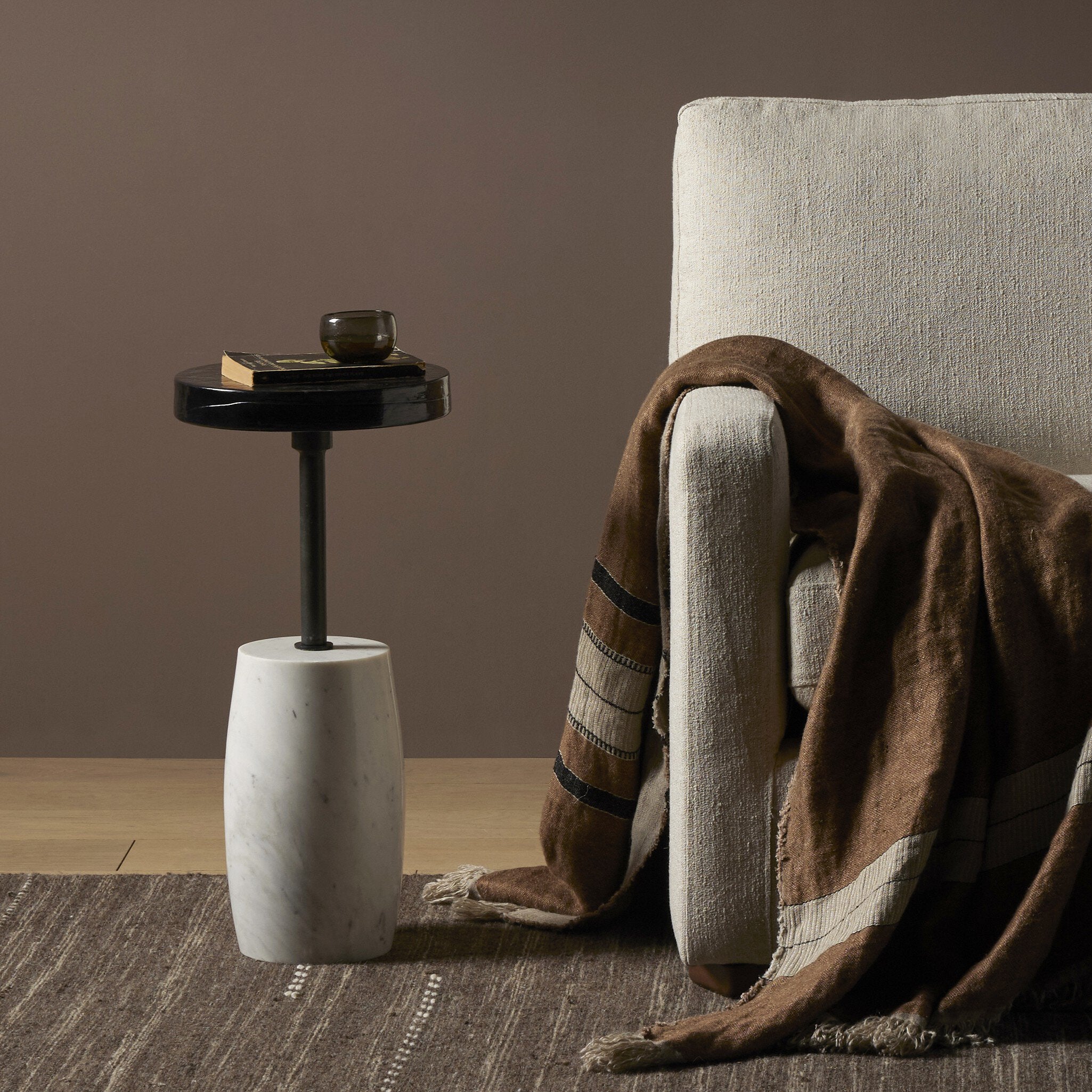 Mesa lateral con pedestal de mármol sólido y vidrio artesanal Atelier en una sala.