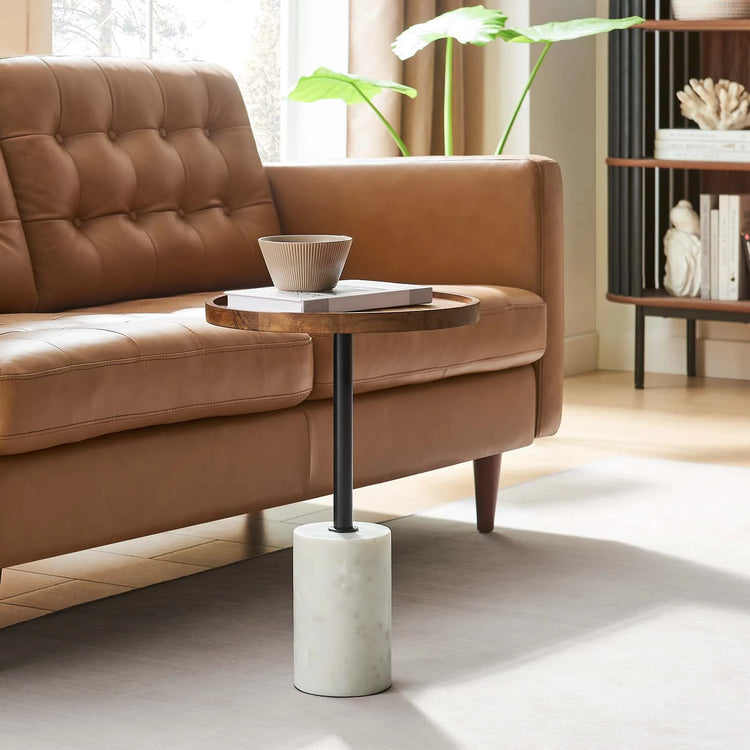 Mesa lateral redonda de madera de Acacia café Epira en una sala.