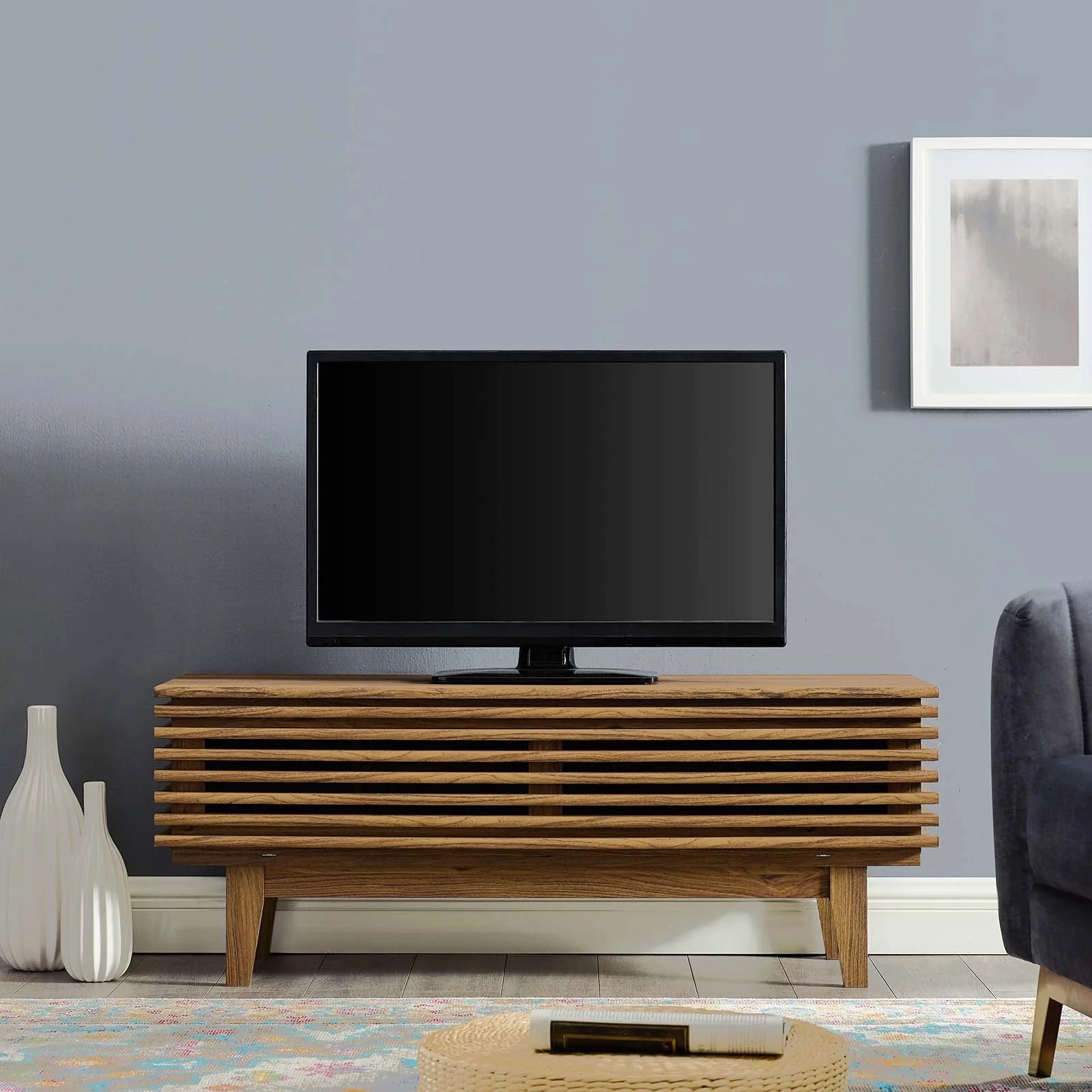 Mueble de 46” para TV Niklas color nogal en una sala.