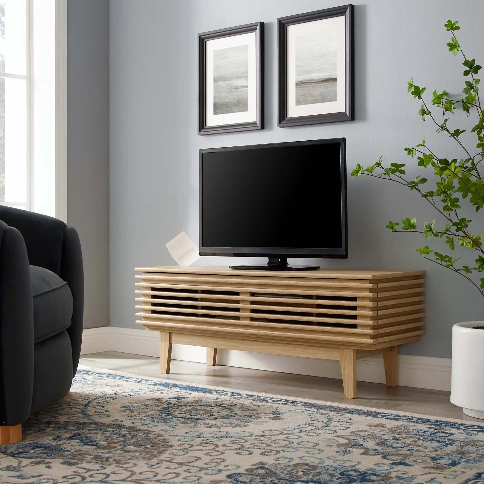 Mueble de 46” para TV Niklas color roble en una sala.