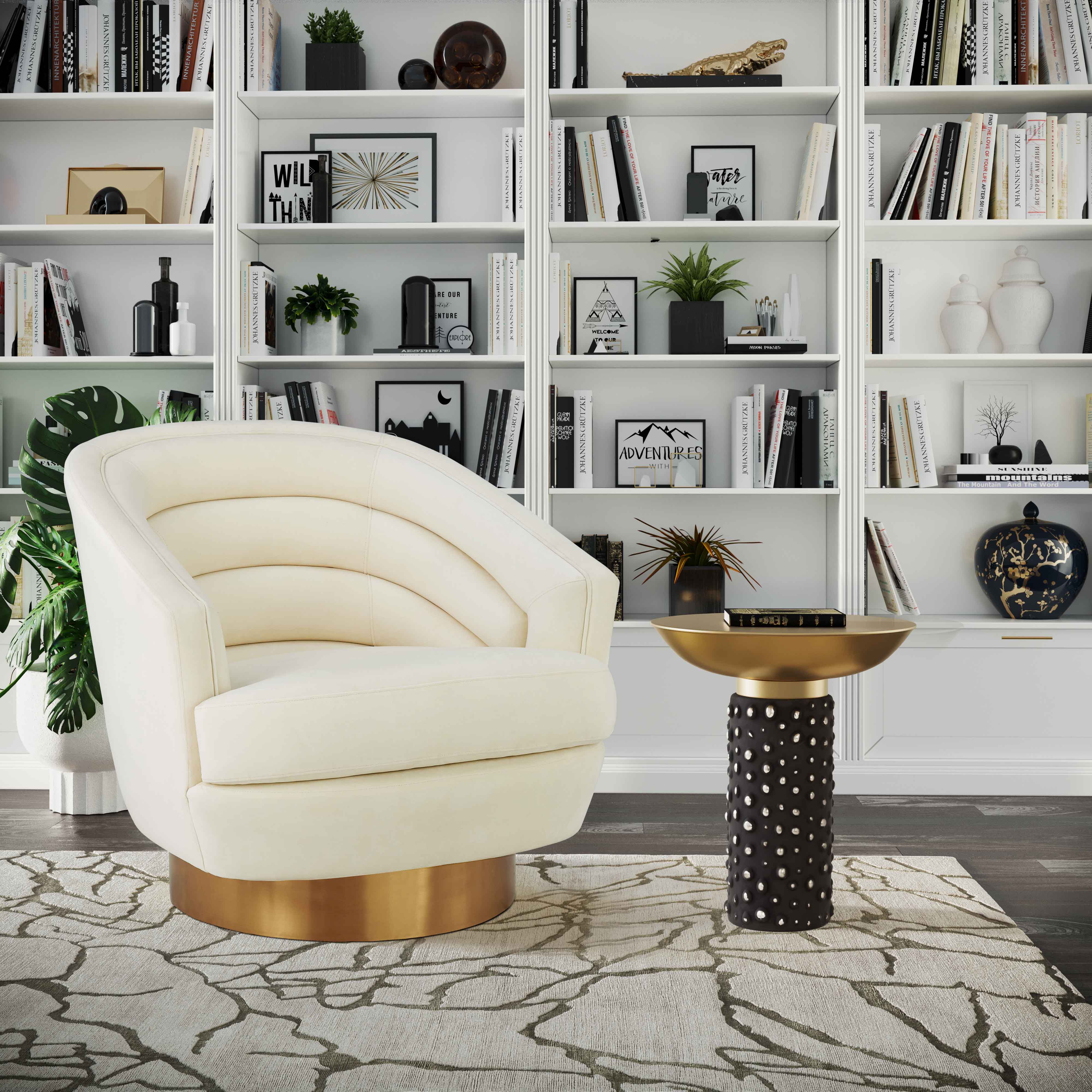 Silla de acento de terciopelo crema y base dorado cepillado Ara en una sala.