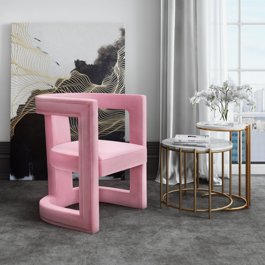 Silla de acento de terciopelo rosa Abantza en una sala moderna.