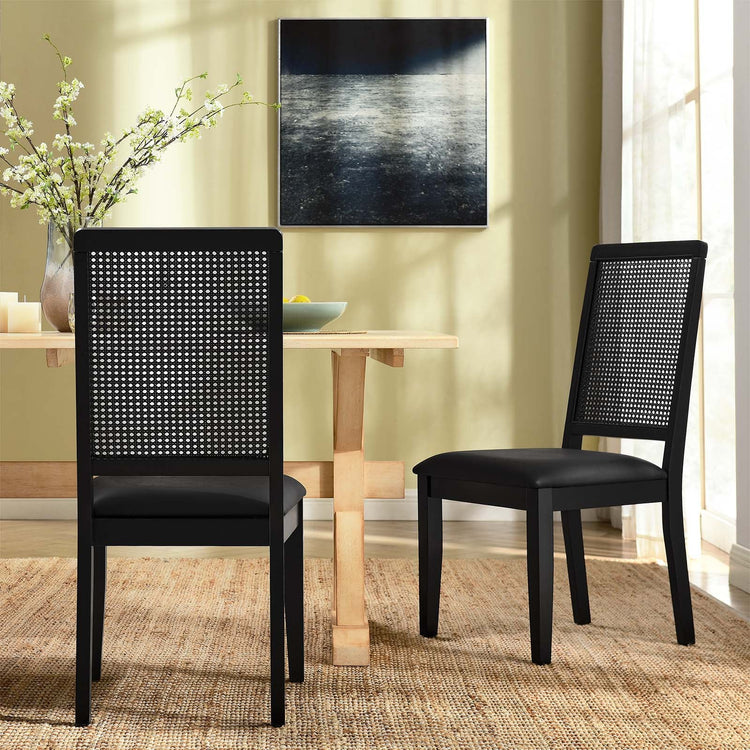 Silla de comedor de piel vegana color negro marco negro con ratán sintético Enzo en un comedor.