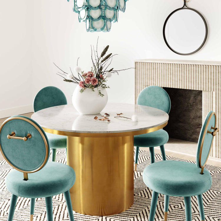 Silla mecedora de terciopelo azul mar Ellyn en un comedor.