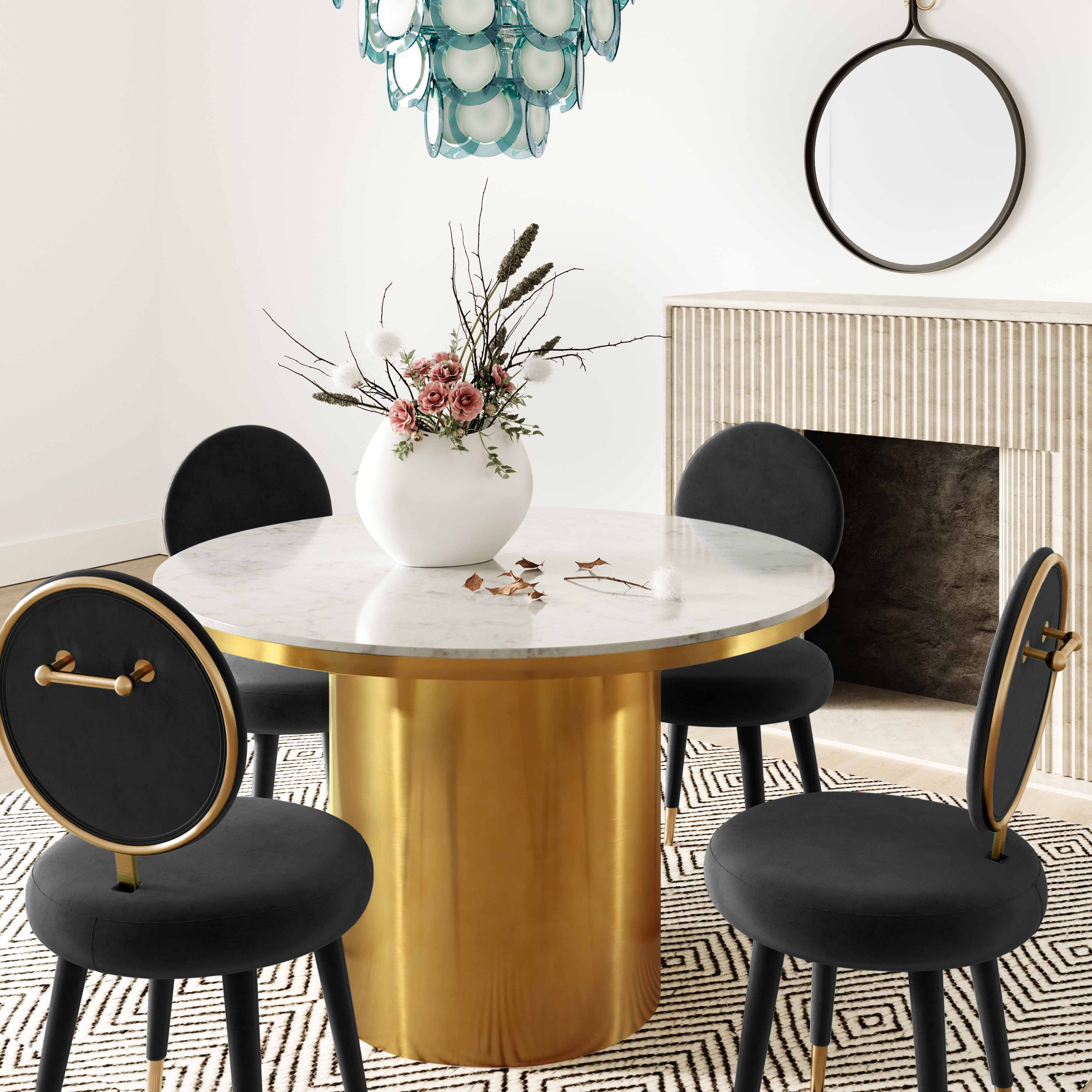 Silla mecedora de terciopelo negro Ellyn en un comedor.