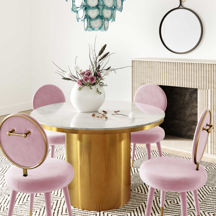 Silla mecedora de terciopelo rosa chicle Ellyn en un comedor.
