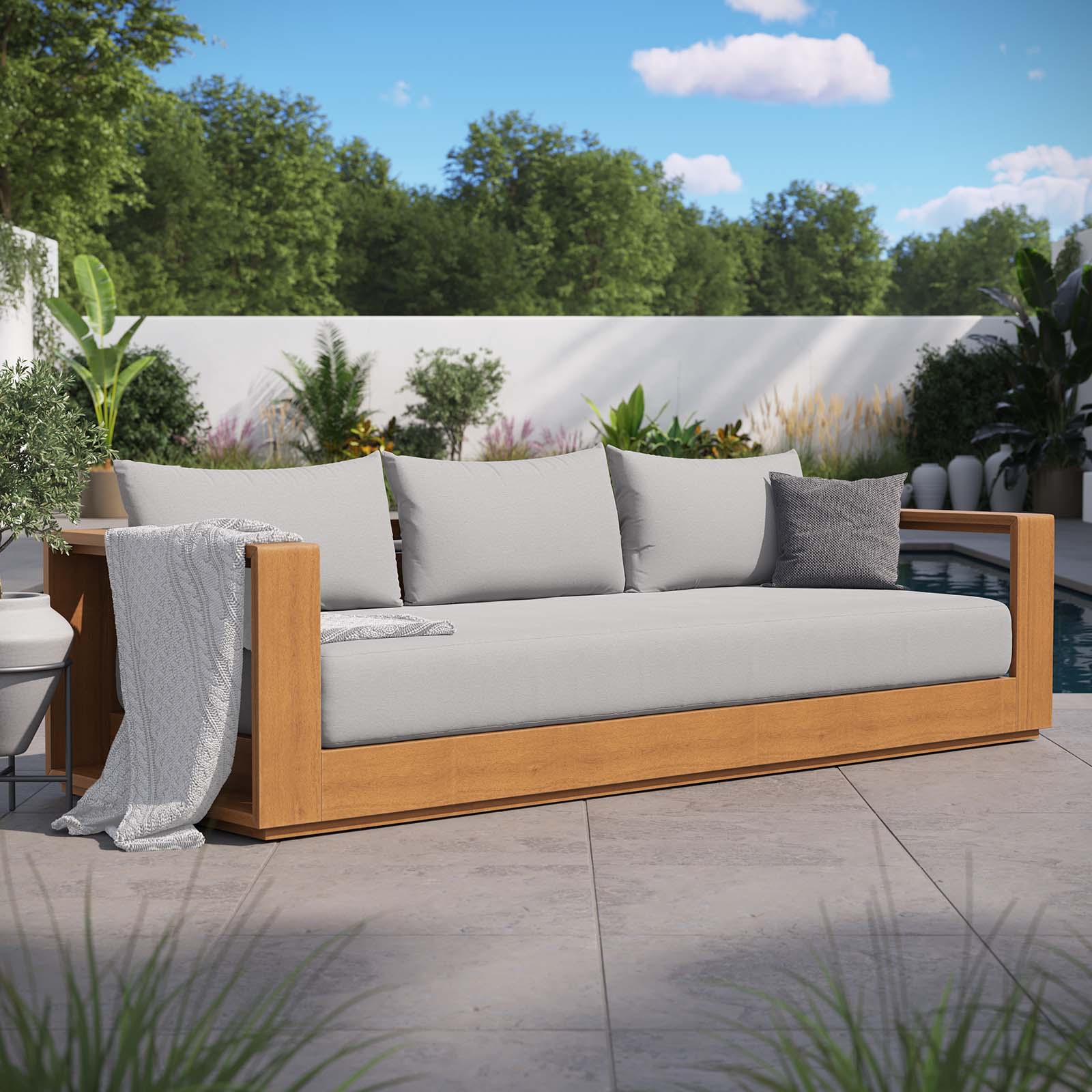 Sillón para exterior de madera de acacia Neuba en el exterior.