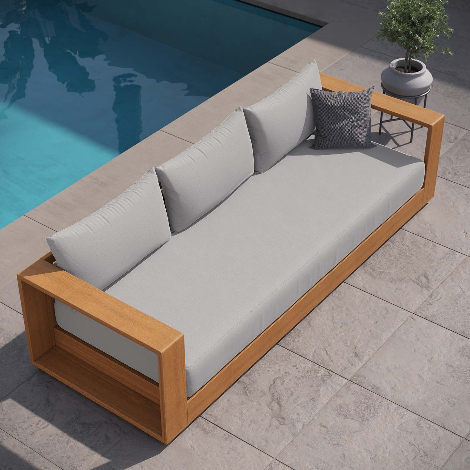 Sillón para exterior de madera de acacia Neuba al lado de una alberca.