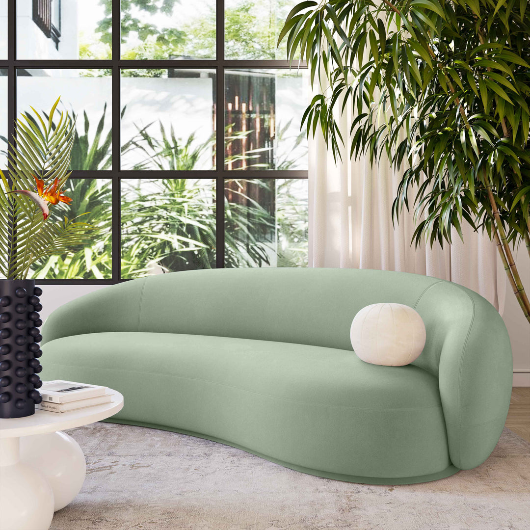Sofá de terciopelo verde musgo Avery en una sala moderna.