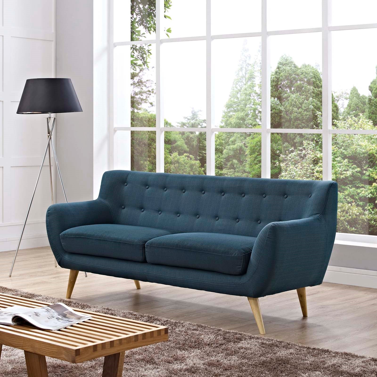 Sofá tapizado de tela en azul Silo Notable Mobiliario en una sala moderna.